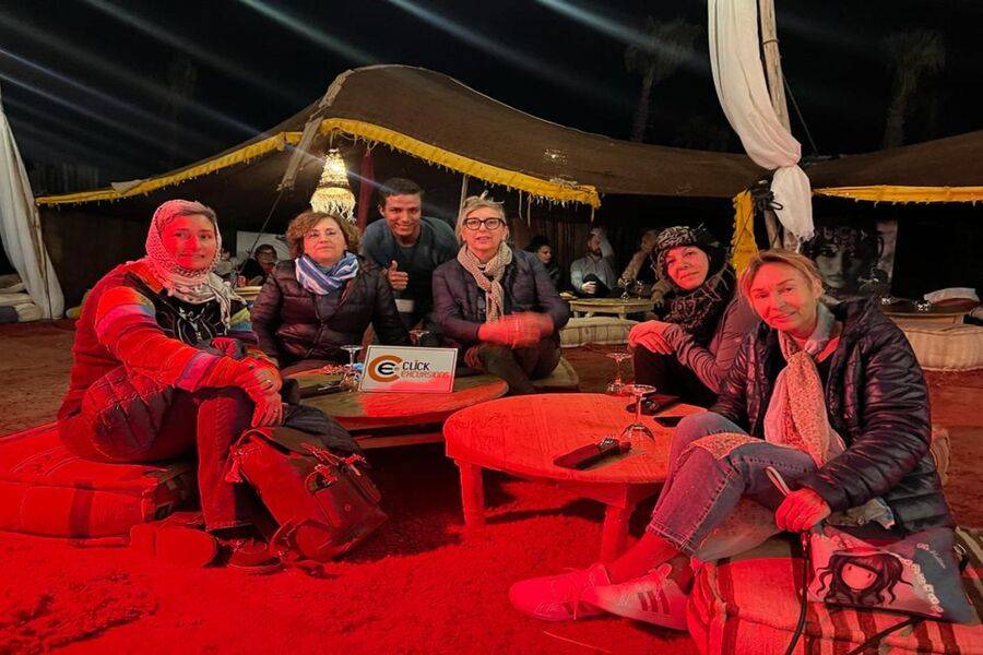 Happy travelers enjoying a traditional Moroccan meal during an Agafay desert dinner excursion
